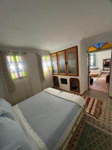 a bedroom with two beds and stained glass windows at Dar fenan Lina in Chefchaouen