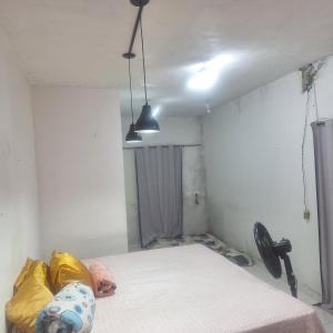 a room with a bed and two pendant lights at Casa da D Luiza in Belém