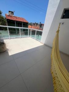 a hammock on a balcony of a house at Casa Miss Paripueira in Paripueira