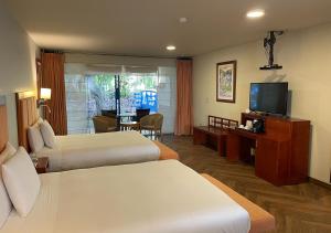 a hotel room with two beds and a flat screen tv at Aranwa Sacred Valley Hotel & Wellness in Urubamba