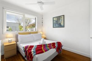 MordiallocにあるRelaxed Bayside Stay with Outdoor Spaceのベッドと窓のある白い寝室