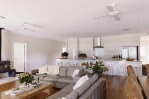 a living room with a couch and a kitchen at Semillon Retreat in Pokolbin