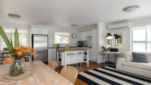 a kitchen and living room with a table and a couch at Walk To Beach, Pet Friendly Trampoline in Umina