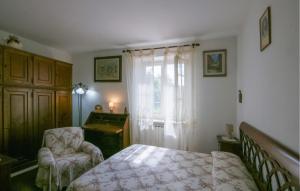 a bedroom with a bed and a chair and a window at 2 Bedroom Beautiful Apartment In Querceta in Querceta
