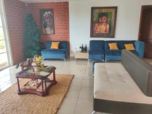 a living room with blue couches and a brick wall at Habitación confort in Puyo