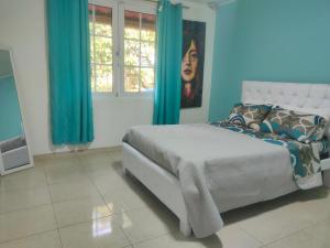 a bedroom with a large bed with blue curtains at Habitación confort in Puyo