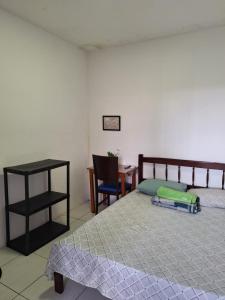 a bedroom with a bed and a table and a chair at Cozinha e Lavadora Compartilhadas Qto e Wc privativos in São Luís
