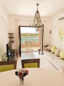 a living room with a couch and a table at Nayah Stays, Cozy lagoons terrace one ensuite Apt in Hurghada