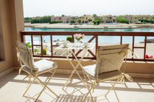 a table and chairs on a balcony with a view at Nayah Stays, Cozy lagoons terrace one ensuite Apt in Hurghada