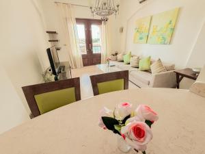 a table with a vase with flowers on it in a living room at Nayah Stays, Cozy lagoons terrace one ensuite Apt in Hurghada