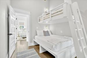 a white bedroom with a bunk bed and a doorway at Sun Chaser Cottage 205 FIV-D in Port Aransas +52 photos