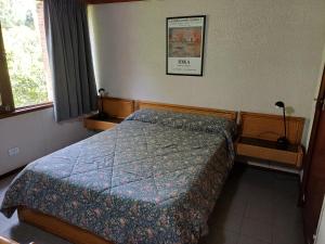 Un dormitorio con una cama con un edredón azul. en Tiempo Compartido Clermont Pinamar, en Pinamar