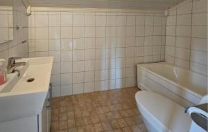 a bathroom with a sink and a toilet and a tub at Gorgeous Home In Eggedal With Sauna in Surteberg