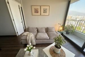 a living room with a couch and a large window at Ñuñoa I Estadio Nacional in Santiago