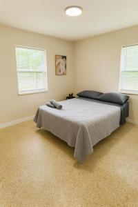 a bedroom with a large bed with two windows at The Awali in Miami