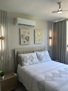 a bedroom with a bed with a white comforter at Confortable Apartamento in Barranquilla +41 photos