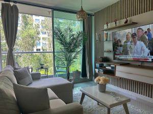 a living room with a couch and a tv at Confortable Apartamento in Barranquilla