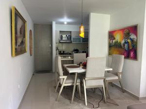 a kitchen and dining room with a table and chairs at Confortable Apartamento in Barranquilla