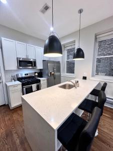 een keuken met een wit aanrecht en zwarte apparaten bij Flexhome West Town 2BR Duplex Apt T2 in Chicago