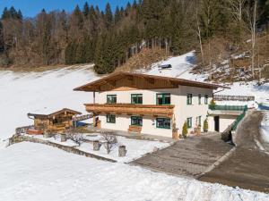 a house in the snow with snow covered ground at Haus am Waldrand in Hopfgarten im Brixental