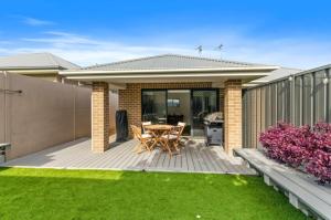a deck with a table and chairs in a backyard at The Stayover Unit 2 - Your Wine Country Base in North Rothbury +1 photo