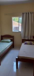 En eller flere senge i et værelse på Apartamento Aconchegante