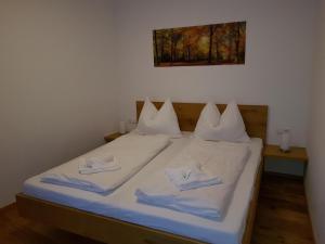 a bed with white sheets and towels on it at Galsterberg in Gröbming