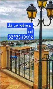 a street light with a sign in front of a beach at Da Cristina appartamento in Sciacca