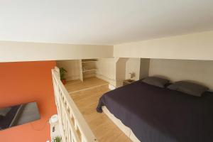 a bedroom with a black bed and a staircase at Lumineux T3 Sur La Place de La Comédie, Très Calme in Montpellier