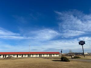 a building with a red roof and a sign in front at Northern Lights Inn & Suites in Valleyview
