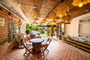 an outdoor patio with tables and chairs and chandeliers at Hotel Glamping La Polka in Amagá