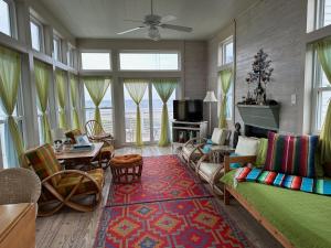 a living room with a green couch and chairs at Beachfront Melody in Galveston