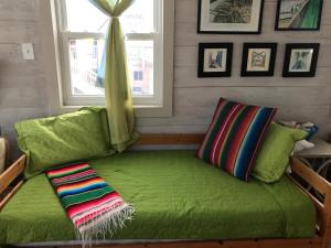 a green couch in a room with a window at Beachfront Melody in Galveston