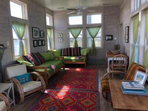 a living room with a green couch and chairs at Beachfront Melody in Galveston