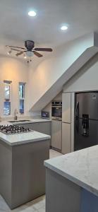 a kitchen with stainless steel appliances and a ceiling fan at Mima's Village Cozumel in Cozumel