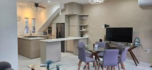 a kitchen and dining room with a table and purple chairs at Mima's Village Cozumel in Cozumel