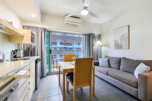 eine Küche und ein Wohnzimmer mit einer Couch und einem Tisch in der Unterkunft Darwin City Centre Apt 2 Bed, 2 Bath in Darwin