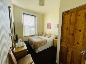 une petite chambre avec un lit et une fenêtre dans l'établissement Alister Guest House, à Saint-Hélier 10 autres photos