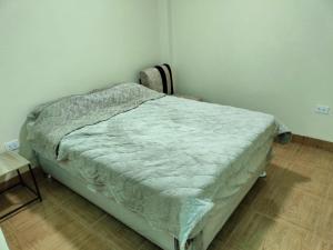 een bed in een kamer met een houten vloer bij Sol de Paracas in Pisco