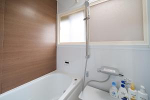 a bathroom with a tub and a sink and a window at コルネット館山 in Tateyama +38 photos