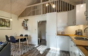 Una cocina con gabinetes blancos y una mesa. en Gorgeous Home In Svanskog With Wifi, en Svaneholm