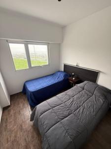 a bedroom with two beds and a window at Hotel&Vermú AREIA a metros del mar in Mar del Plata