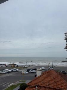 a parking lot with cars parked next to the beach at Hotel&Vermú AREIA a metros del mar in Mar del Plata