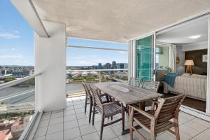 a dining room with a table and chairs and a balcony at Coastal Escape with River Views in Casino Towers in Brisbane