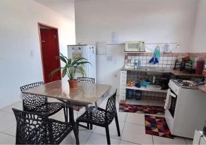 a kitchen with a table and chairs and a kitchen with a refrigerator at Quarto TOP perto do Centro e Praias AR TV Wifi Cozinha Lavadora in São Luís