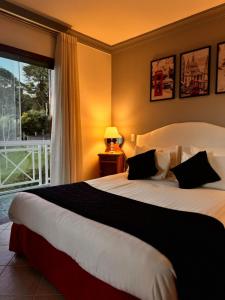 a bedroom with a large bed and a window at Pousada de Charme Vila Natal in Campos do Jordão