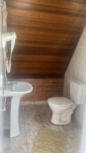 ein Badezimmer mit Toilette und Waschbecken in der Unterkunft Chalé Represa Varanda do Sol - Chalé Alvenaria in Joanópolis