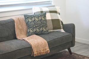 a blanket on a couch with two pillows on it at Charming Centrally Located Treasure Valley Custom in Nampa +78 photos