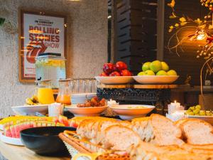 a buffet of food with bread and fruit on a table at Hashtag 98 Hotel By Jalo in Medellín +50 photos