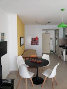 a living room with a table and white chairs at Palermo Quenns - Apartament Premiun in Buenos Aires